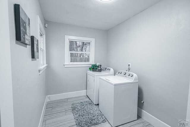 laundry area with laundry area, baseboards, and separate washer and dryer