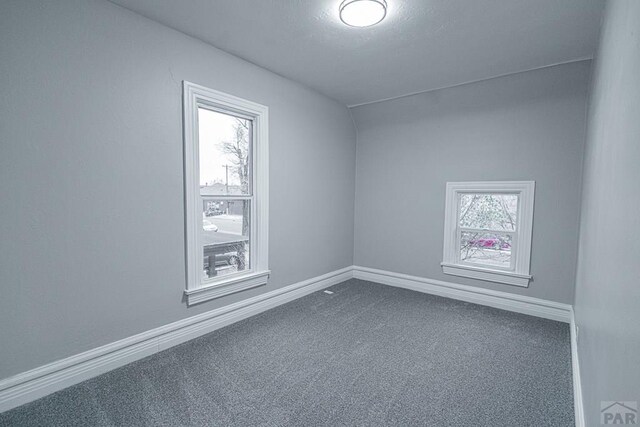 unfurnished room with carpet floors and baseboards