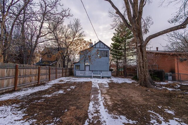 snow covered property featuring a fenced backyard and a wooden deck