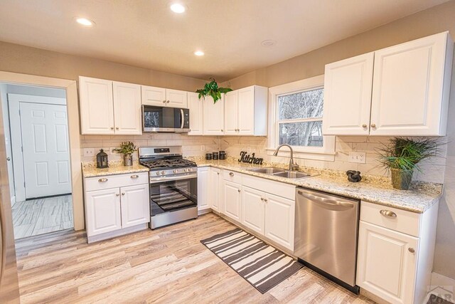 kitchen featuring appliances with stainless steel finishes, recessed lighting, a sink, and white cabinets