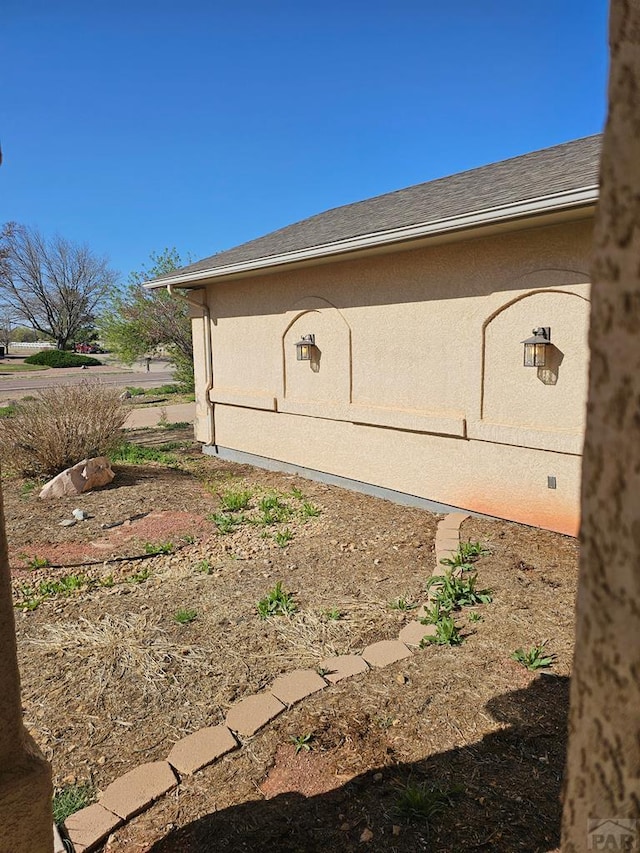 view of home's exterior featuring stucco siding and a shingled roof