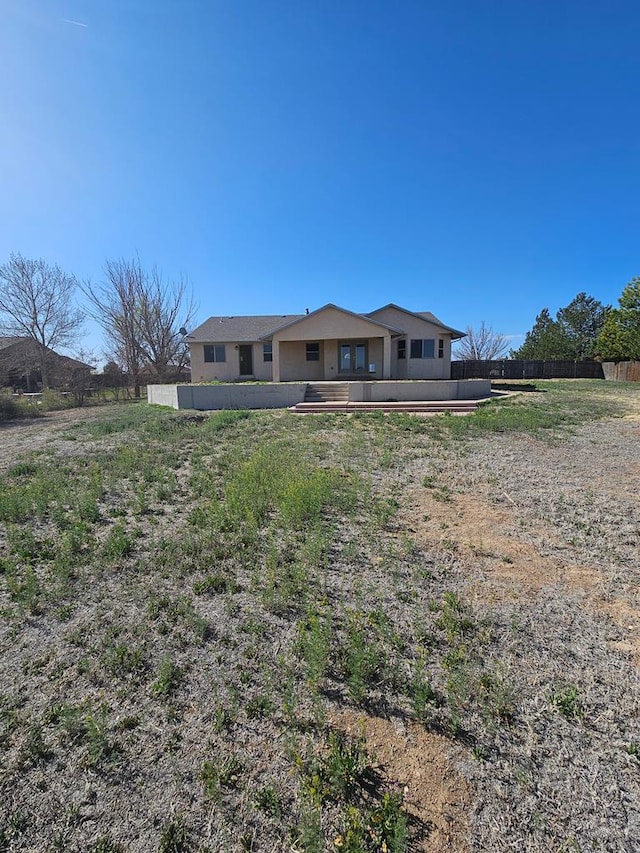 rear view of property featuring fence