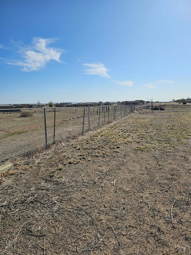 view of yard featuring a rural view and fence