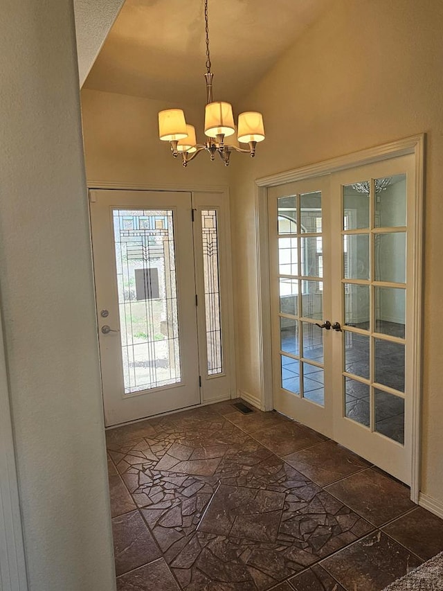 doorway to outside featuring baseboards, an inviting chandelier, stone tile floors, french doors, and lofted ceiling