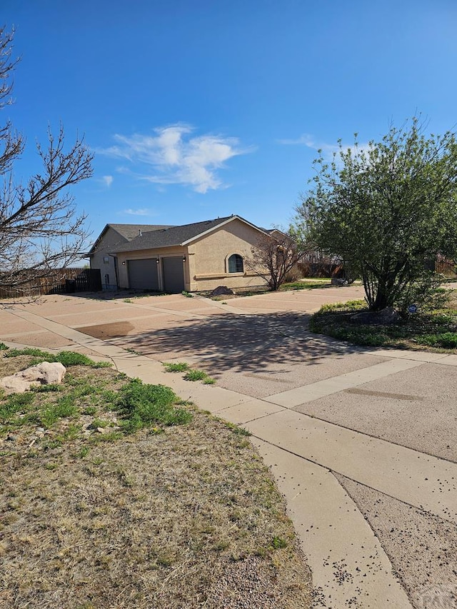 single story home with an attached garage, stucco siding, and concrete driveway