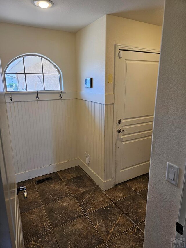 interior space with visible vents and a wainscoted wall