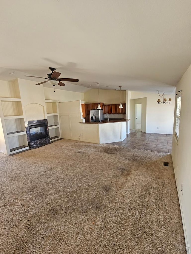 unfurnished living room with visible vents, a ceiling fan, carpet flooring, a glass covered fireplace, and lofted ceiling