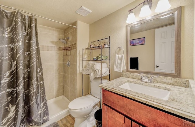 bathroom featuring visible vents, toilet, wood finished floors, a tile shower, and a textured wall