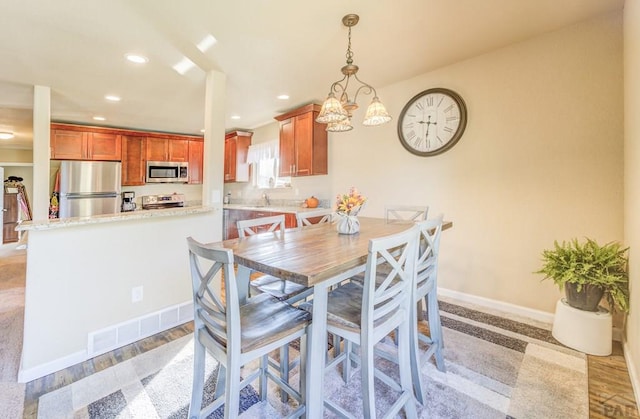 dining room with light wood-type flooring, visible vents, baseboards, and recessed lighting