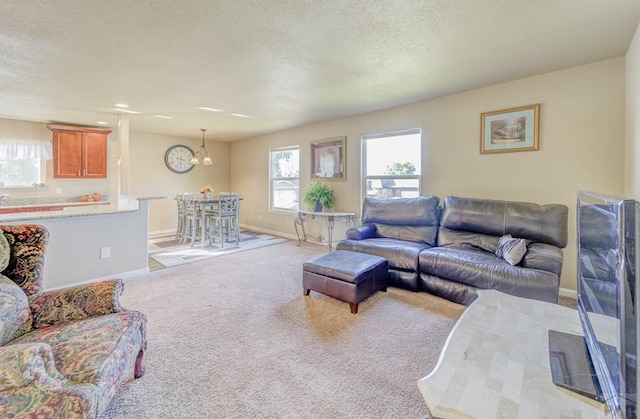 carpeted living area with a textured ceiling and baseboards