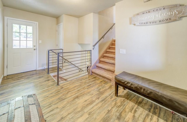 foyer entrance featuring stairway and wood finished floors