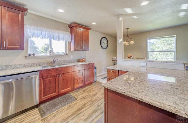 kitchen with dishwasher, plenty of natural light, light wood finished floors, and a sink