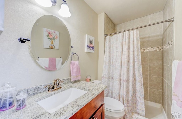 full bathroom featuring toilet, vanity, and a tile shower