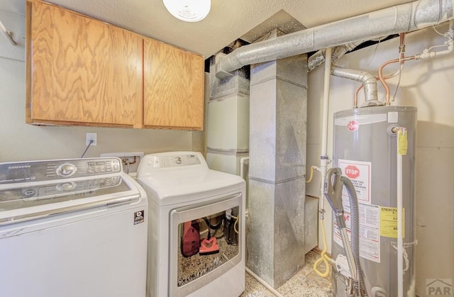 washroom with cabinet space, gas water heater, and washer and dryer