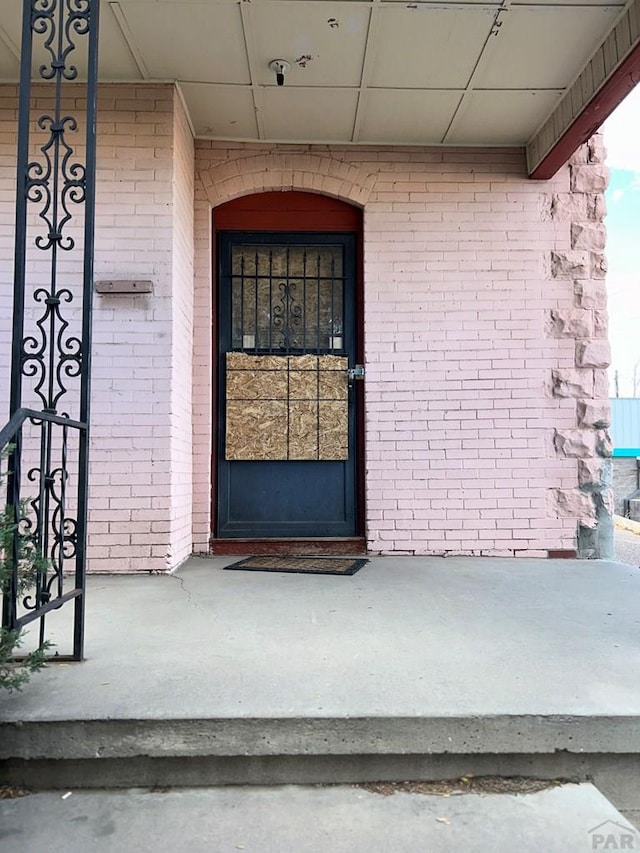 view of exterior entry with brick siding