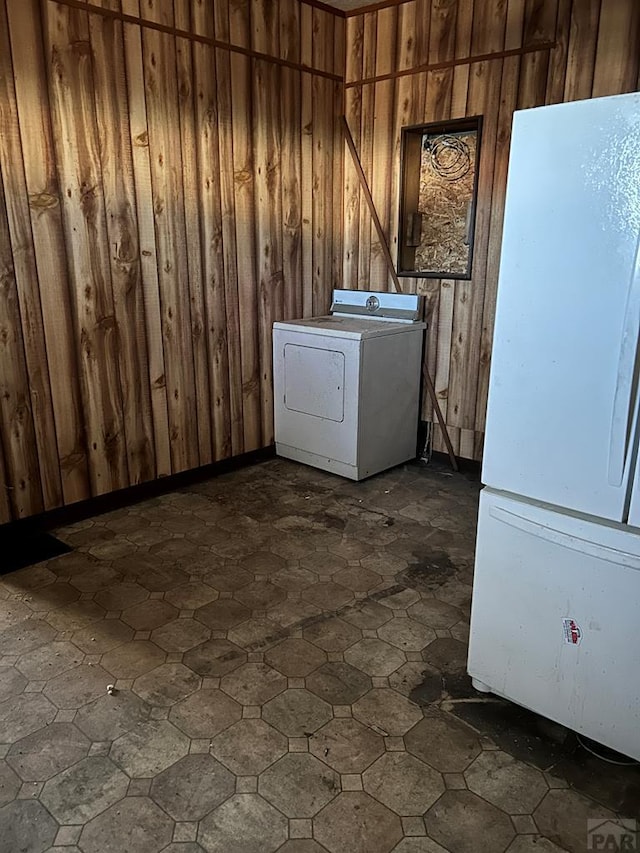 laundry area featuring wood walls, laundry area, and washer / clothes dryer