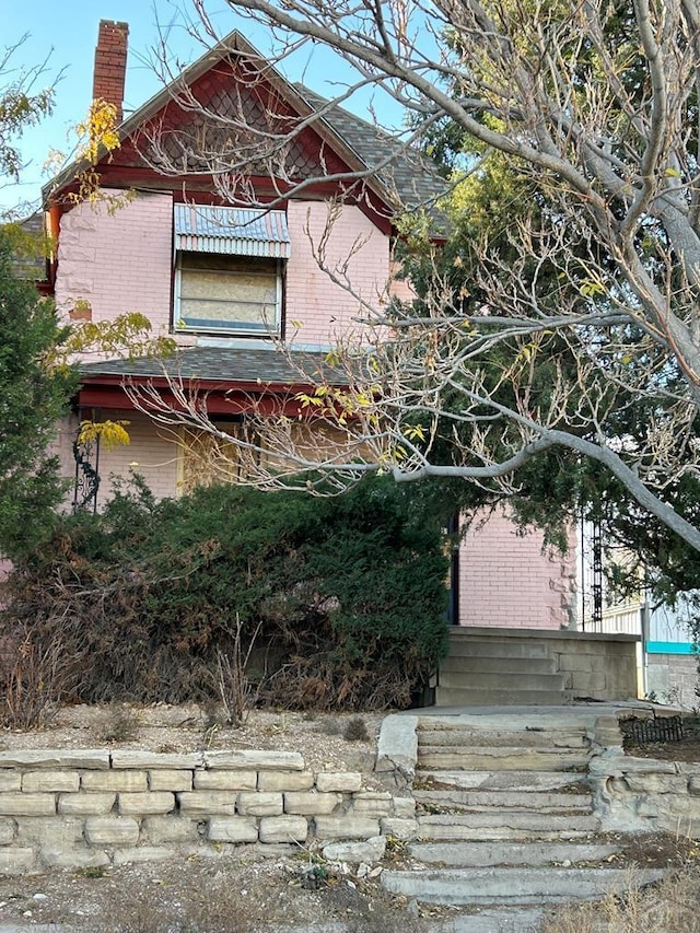 view of property exterior featuring brick siding and a chimney