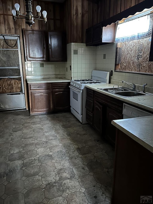 kitchen with white appliances, a sink, light countertops, dark brown cabinets, and backsplash