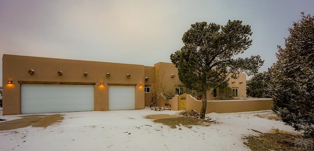 adobe home featuring a garage and stucco siding