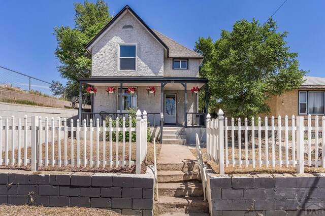 219 E 2nd St, Pueblo, CO 81003 - view of front of house with covered porch and a fenced front yard