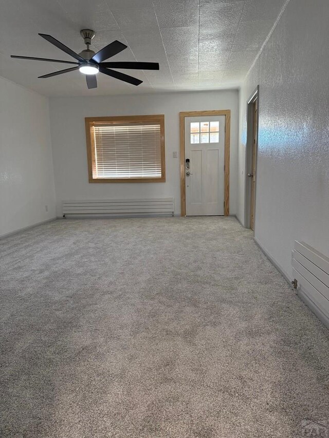 interior space with light carpet, a baseboard radiator, and ceiling fan