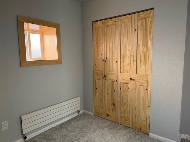 110 W 10th St, Walsenburg, CO 81089 - unfurnished bedroom with carpet floors, baseboards, a baseboard heating unit, and a closet
