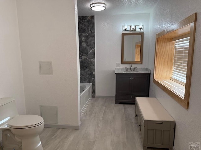 110 W 10th St, Walsenburg, CO 81089 - bathroom with toilet, vanity, a textured ceiling, wood finished floors, and baseboards