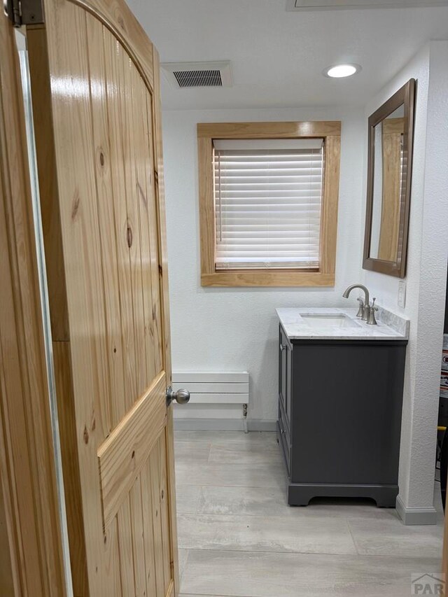 bathroom featuring recessed lighting, wood finished floors, vanity, visible vents, and baseboards