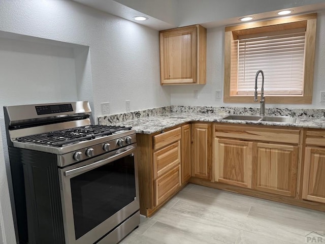 110 W 10th St, Walsenburg, CO 81089 - kitchen featuring stainless steel gas range, recessed lighting, a sink, and light stone countertops