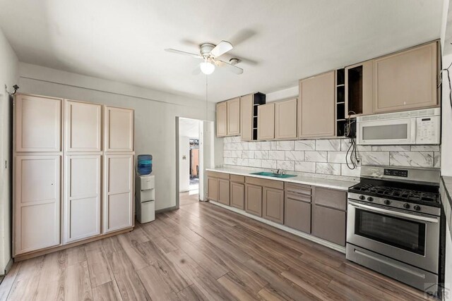 616 E 5th St, Pueblo, CO 81001 - kitchen with a ceiling fan, tasteful backsplash, gas stove, light countertops, and white microwave