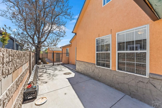 616 E 5th St, Pueblo, CO 81001 - view of side of property with a fenced backyard, a patio, and stucco siding