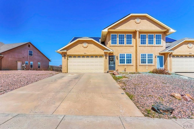 single story home featuring an attached garage, concrete driveway, and stucco siding