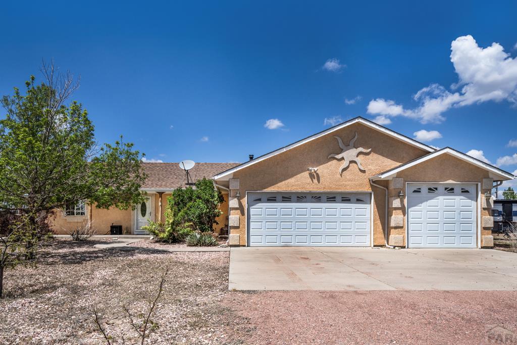 935 W Camino Pablo Ct, Pueblo West, CO 81007 - ranch-style house with stucco siding, driveway, and an attached garage