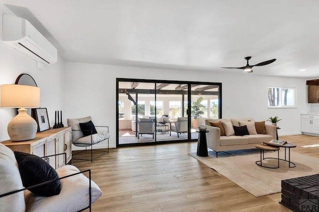 living room with light wood-style floors, ceiling fan, baseboards, and an AC wall unit