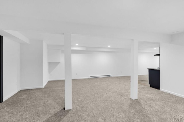 finished basement with a baseboard radiator, light carpet, baseboards, and recessed lighting