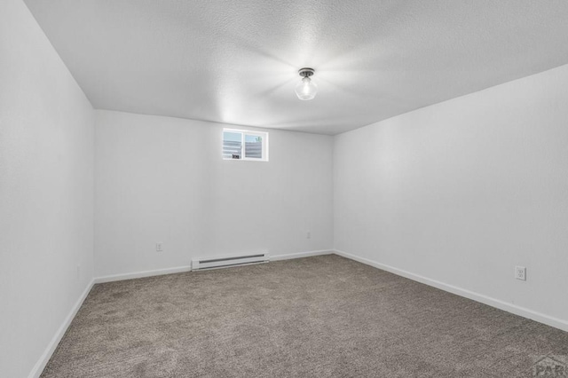 carpeted empty room featuring a textured ceiling, baseboard heating, and baseboards