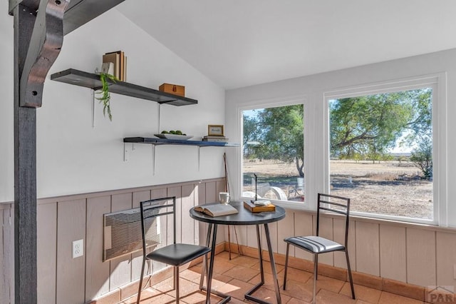 dining area featuring vaulted ceiling, wainscoting, plenty of natural light, and heating unit