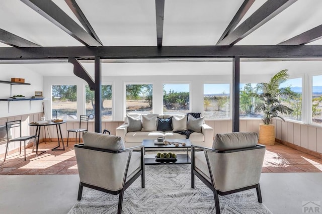 sunroom / solarium with beam ceiling and a fireplace