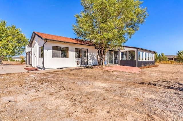 rear view of house featuring a sunroom