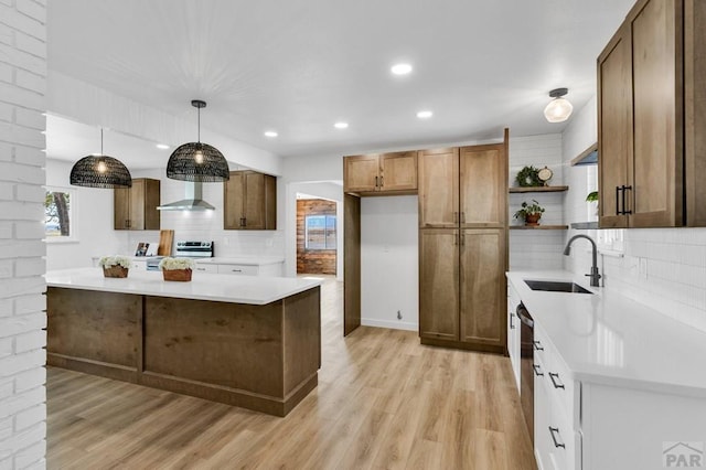 kitchen with brown cabinetry, hanging light fixtures, light countertops, open shelves, and a sink