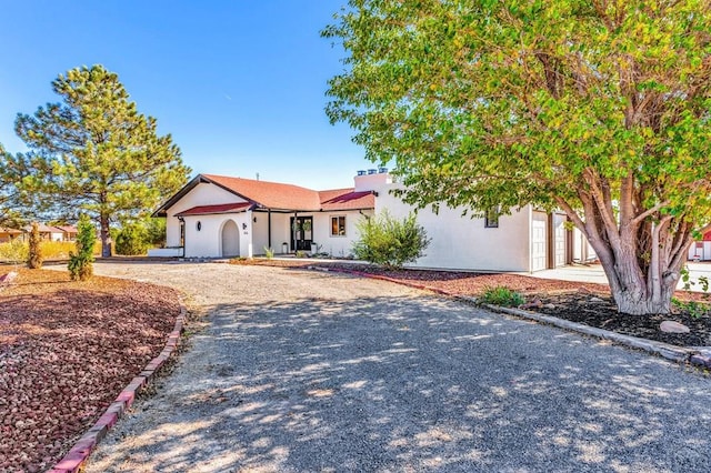 view of front of home with gravel driveway and stucco siding