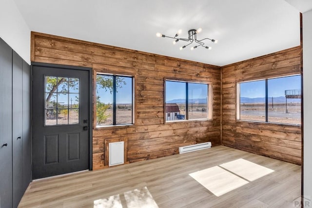 interior space featuring a chandelier, light wood-style floors, baseboard heating, and a mountain view