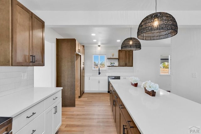 kitchen with open shelves, light countertops, white cabinetry, a sink, and dishwasher