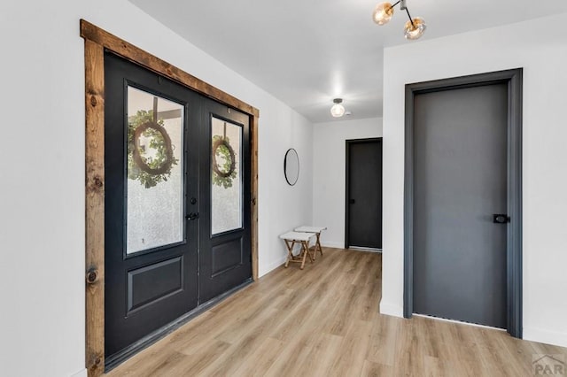 foyer with light wood-style flooring and baseboards