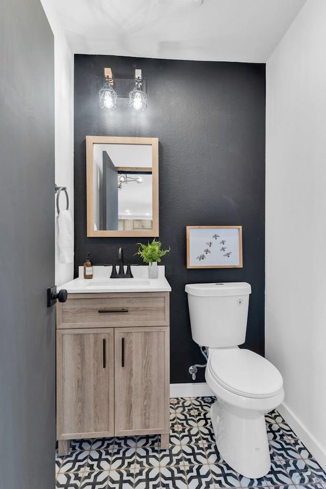 bathroom featuring tile patterned flooring, vanity, toilet, and baseboards