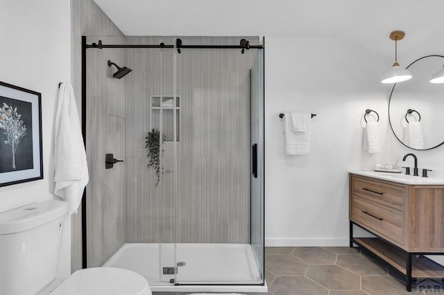 bathroom with tile patterned flooring, toilet, vanity, baseboards, and a shower stall