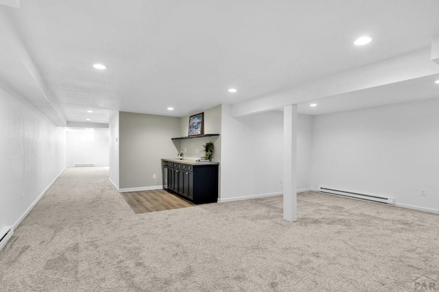 finished basement with carpet floors, a baseboard radiator, baseboards, and recessed lighting