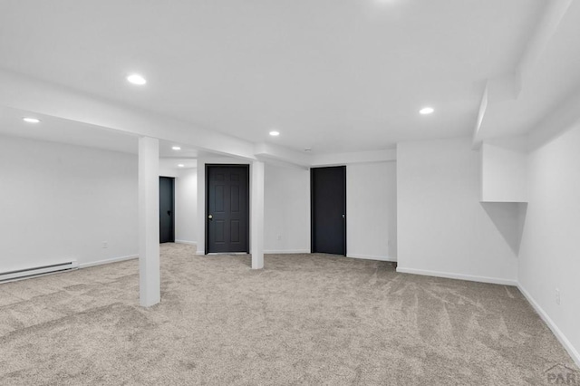 finished below grade area featuring recessed lighting, light colored carpet, baseboards, and a baseboard radiator