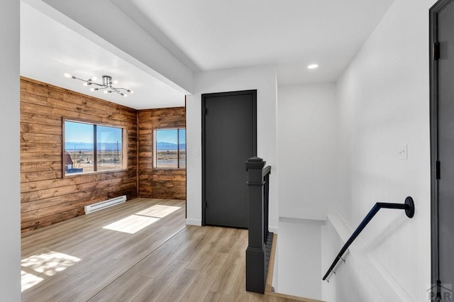 interior space with wood walls, light wood-style flooring, baseboard heating, and recessed lighting