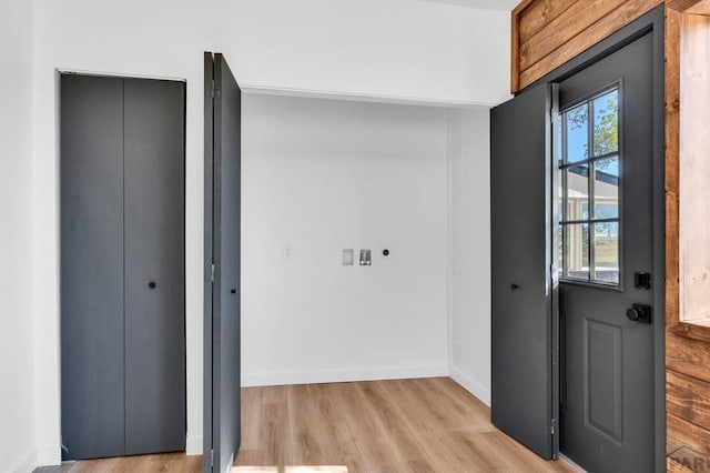 doorway to outside with light wood-type flooring and baseboards